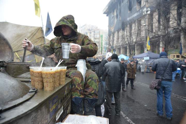 A volunteer hands out cups of soup in Kyiv's Independence Square.