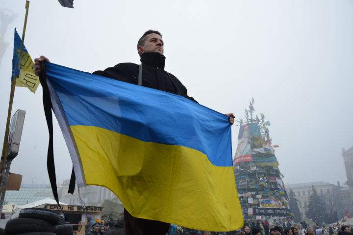 A man holds up a Ukrainian flag in Kyiv's Independence Square, where protesters continue to camp out after three months of anti-government demonstrations.