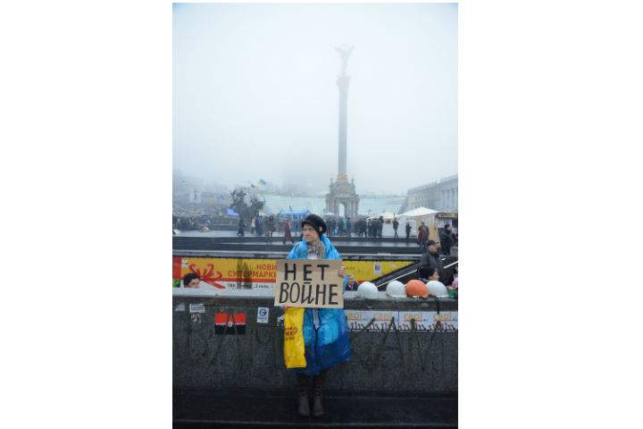 A protester in Kyiv's Independence Square holds a sign that reads "No War."