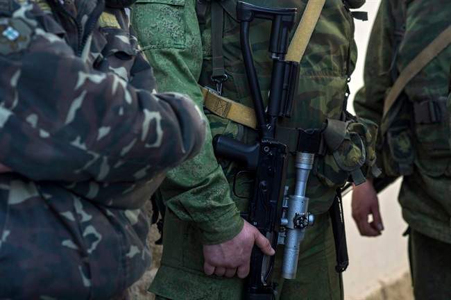 Unidentified gunmen stand outside entrance to the General Staff Headquarters of the Ukrainian Navy in Sevastopol, Ukraine, Monday, March 3, 2014. 