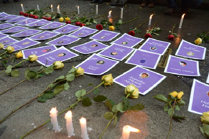 Candles and flowers are placed next to the pictures and names of those missing from the downtown eastside during a small vigil during the delivery of the report of the Missing Women Inquiry in Vancouver, Dec.17, 2012. THE CANADIAN PRESS/Jonathan Hayward.