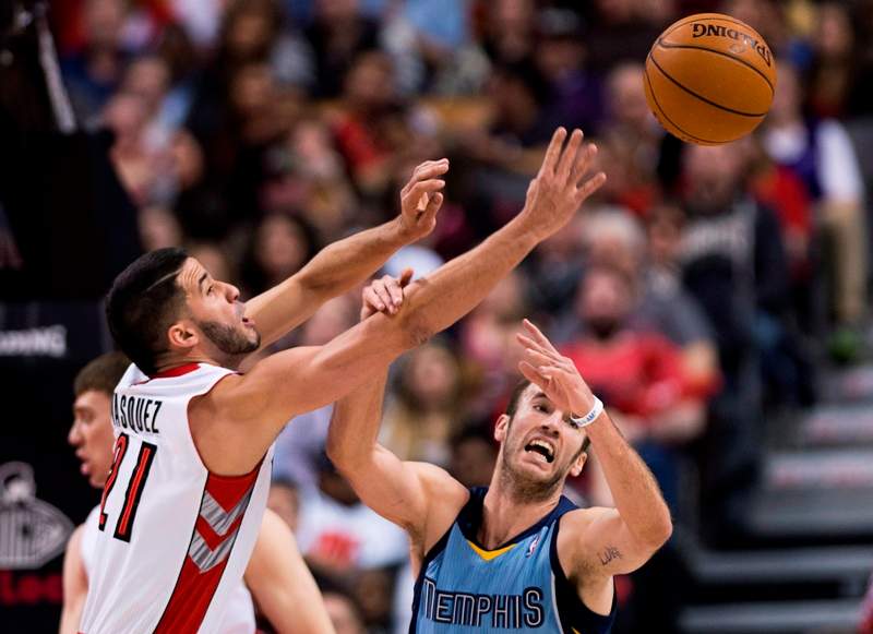 Toronto Raptors guard Greivis Vasquez, left, battlesd for the loose ball against Memphis Grizzlies guard Nick Calathes, right, during first half NBA basketball action in Toronto on Friday, March. 14, 2014. THE CANADIAN PRESS/Nathan Denette.