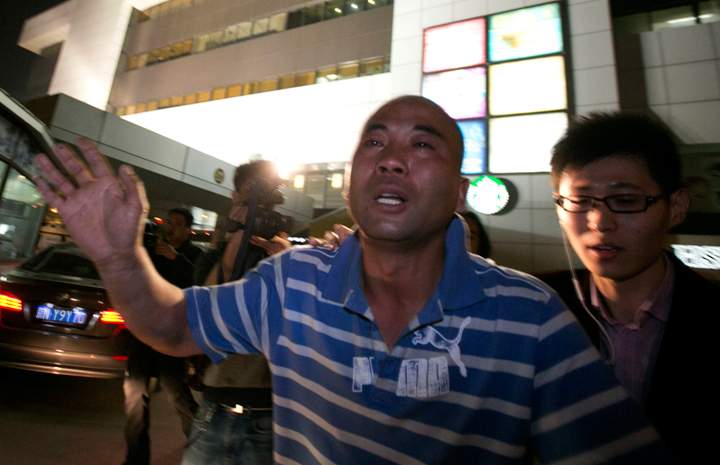 A relative of one of the Chinese passengers aboard the Malaysia Airlines jet, MH370, runs out of the hotel in tears after being told of the latest news in Beijing, China, Monday, March 24, 2014.