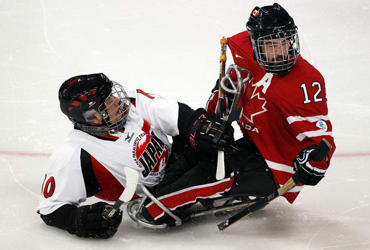 Takayuki Endo #10 of Japan collides with Greg Westlake #12 of Canada during the second period of the Ice Sledge Hockey Play-off Seminfinal Game on day seven of the 2010 Vancouver Winter Paralympic Games at UBC Thunderbird Arena on March 18, 2010 in Vancouver, Canada. 