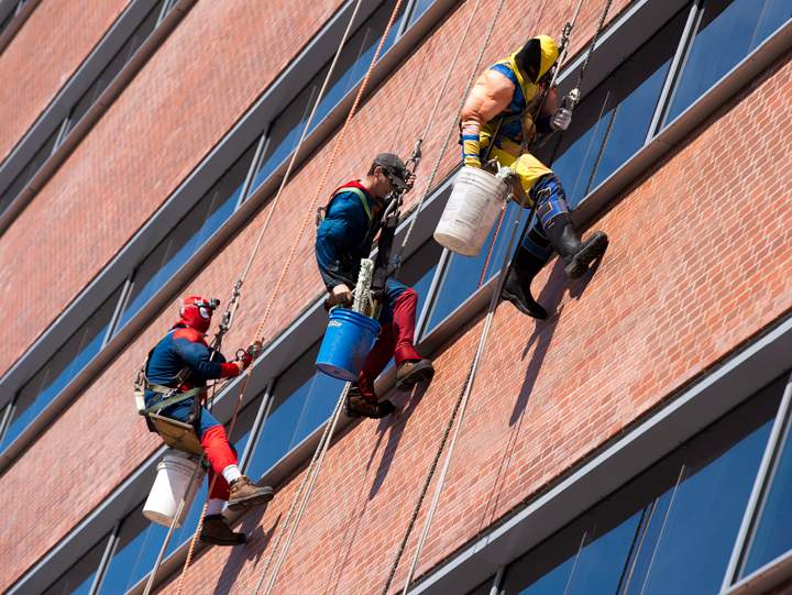 Window washers in superhero costumes wash the windows at Lakeridge Health in Oshawa, Ontario, on Friday, March 21, 2014.