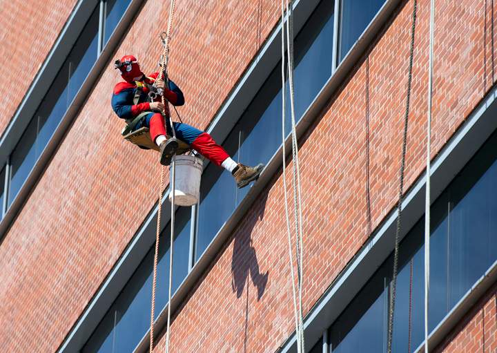 Window washers in superhero costumes wash the windows at Lakeridge Health in Oshawa, Ontario, on Friday, March 21, 2014.