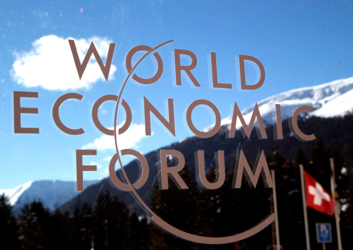 The logo of the Forum is seen through a window with the alps in the background during the World Economic Forum in Davos, Switzerland, Wednesday, Jan. 22, 2014. AP Photo/Michel Euler