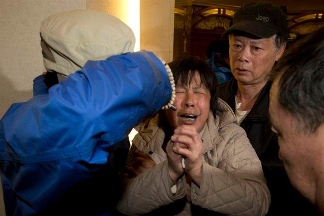 A relative of Chinese passengers aboard the Malaysia Airlines MH370, cries after being told the latest update in Beijing, China, Monday, March 24, 2014.
