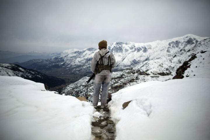 A Pakistani Army soldier with the 20th Lancers Armored Regiment stands atop the 8000-foot mountain during a patrol near his outpost, Kalpani Base, in Pakistan’s Dir province on the Pakistan-Afghan border on Feb. 17, 2012.
