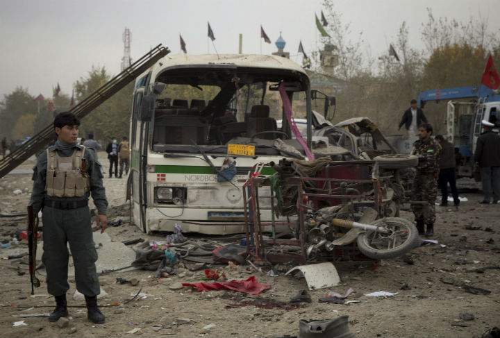An Afghan policeman secures an area after a suicide vehicle bomb tore through the area on the outskirts of Kabul, Saturday, Nov. 16, 2013.