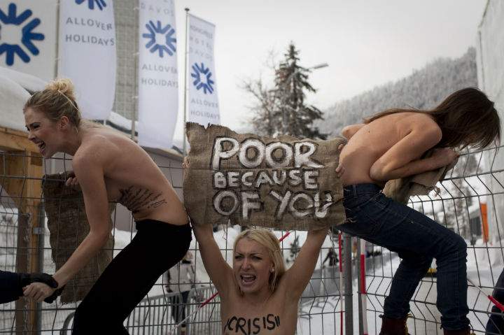 Ukrainian protesters climb up a fence at the entrance to the congress center where the World Economic Forum takes place in Davos, Switzerland on Feb. 17, 2012.