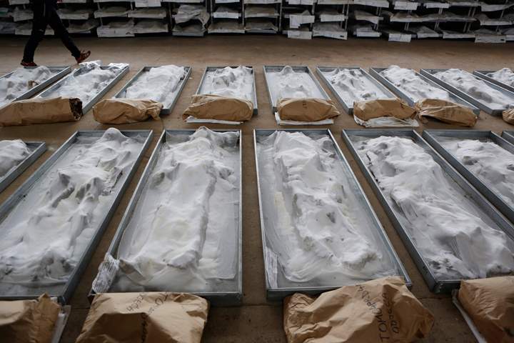 Bosnian technical worker Zlatan Music walks near bodies, conserved with salt, exhumed from the Tomasica mass grave at the Sejkovaca identification center, near the Bosnian town of Sanski Most, 260 kilometres (162 miles) northwest of Sarajevo,  Wednesday, April 16, 2014. 
