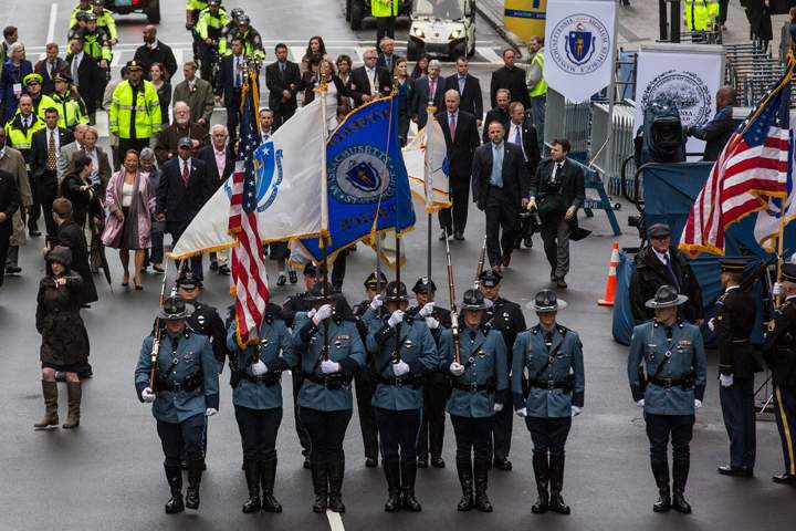 Police officers carry flags during a wreath laying ceremony on the one year anniversary of the 2013 Boston Marathon Bombing, on April 15, 2014 in Boston, Massachusetts.