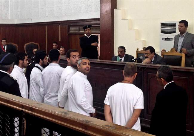 Al-Jazeera English bureau chief Mohamed Fahmy, center, producer Baher Mohamed, center left, and correspondent Peter Greste, second right, stand in a courtroom along with several other defendants during their trial on terror charges, in Cairo, Egypt, Monday, March 31, 2014.