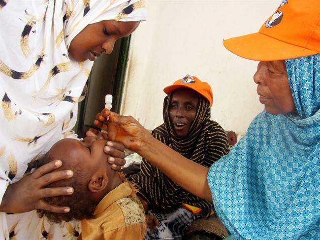A World Health Organization official give a dose of Polio Vaccine to Somali child in Mogadishu, Somalia, Monday, Sept. 11, 2006.