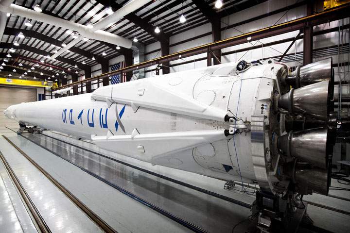 Falcon 9 in SpaceX’s hangar with landing legs attached.
