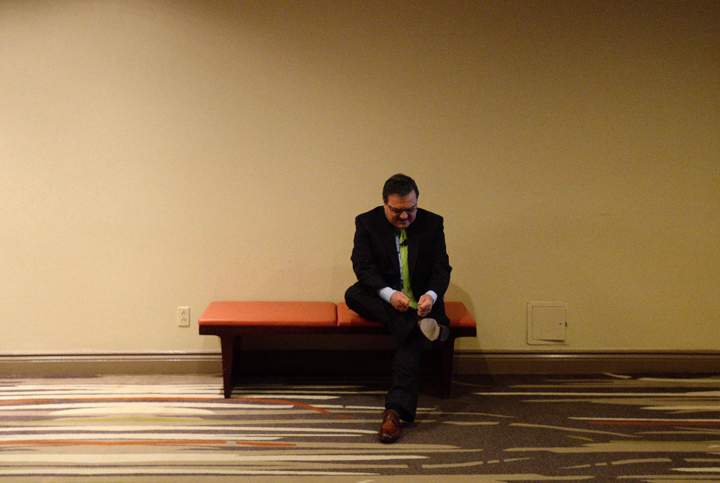Minister of Finance Jim Flaherty ties his shoe before speaking at a post-budget event in Ottawa on February 12, 2014.