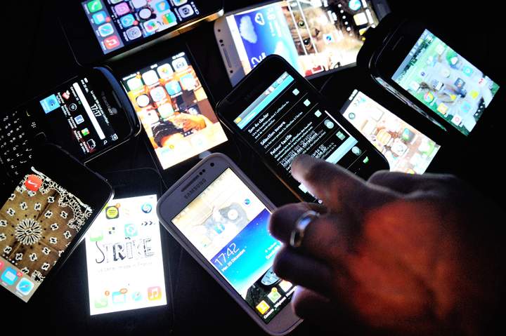 A finger points at smartphones on December 25, 2013 in Dinan, northwestern France. 