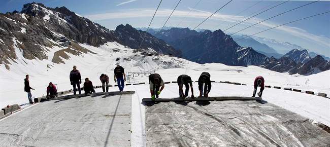 In this May 10, 2011 file photo, workers cover the glacier with oversized plastic sheets on the peak of Germany's highest mountain Zugspitze (2962 meters) near Garmisch-Partenkirchen, southern Germany. The sheets are meant to keep the glacier from melting during the summer months. 