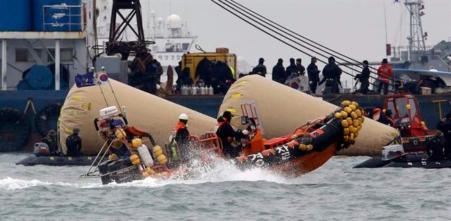 Searchers and divers look for people believed to have been trapped in the sunken ferry boat Sewol near the buoys which were installed to mark the vessel in the water off the southern coast near Jindo, south of Seoul, South Korea, Tuesday, April 22, 2014. 