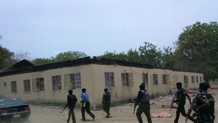 Security walk past burned government secondary school Chibok, where gunmen abducted more than 200 students on Apr. 14.