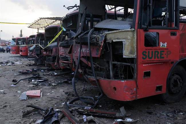 Damaged buses are seen at the scene of an explosion at a bus park in Abuja, Nigeria, Monday, April. 14, 2014.