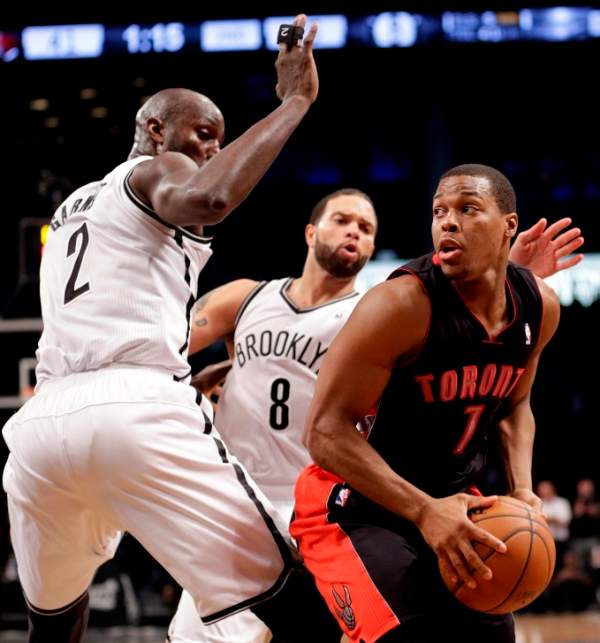 Toronto Raptors' Kyle Lowry (7) looks to pass away from Brooklyn Nets' Kevin Garnett (2) and Deron Williams (8) during the first half of Game 3 of an NBA basketball first-round playoff series Friday, April 25, 2014, in New York. (AP Photo/Frank Franklin II).