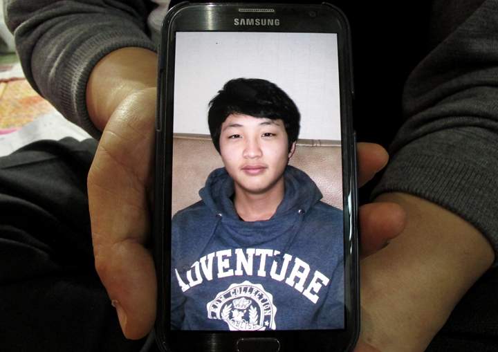 FILE – In this Saturday, April 19, 2014 file photo, a photograph of Nam Hyun-chul is shown by his uncle Lee Jong-eui during an interview at a gymnasium in Jindo, South Korea. Nam, 16, is among the 302 people dead or missing in last week’s South Korean ferry disaster. Hyun-chul’s parents poured their energy, love and attention into their only child, said Lee. Though an overseas education is often pricey, his parents had sent him to school in New Zealand for a while.