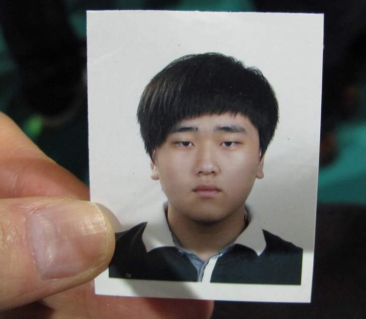 FILE – In this Saturday, April 19, 2014 file photo, a portrait of Lee Seok-joon, one of missing passengers aboard the sunken ferry Sewol, is shown by his father Lee Byung-soo during an interview at a gymnasium in Jindo, South Korea.