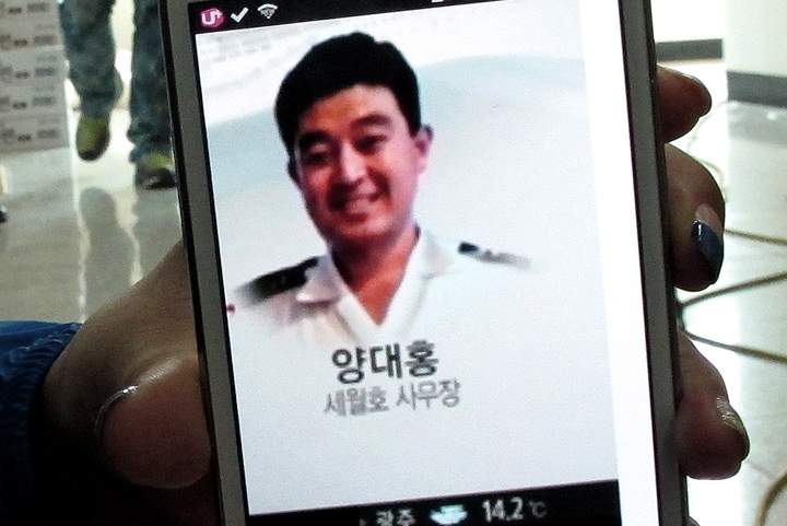 In this Sunday, April 20, 2014 photo, a photograph of Yang Dae-hong, a crew member of the sunken ferry Sewol, is shown by his friend Lee Joung-hwa during an interview at a gymnasium in Jindo, South Korea. Yang, who is among the missing, worked on the Sewol as one of the service staff and went out of his way to help passengers feel at home, even ones who had had a little too much to drink, said Lee, who met him six years ago during an event she organized on the ship. As soon as passengers set foot on the ferry, Yang, 45, would help them up flights of stairs and help carry their luggage or their infants.