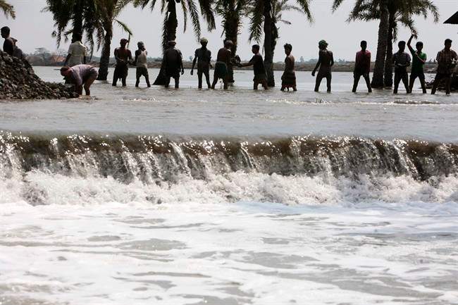 Villagers dig earth to rebuild an embankment at Protap Nagar in Shatkhira, about 176 kilometers southwest of Dhaka, Bangladesh as hundreds of thousands of people were flooded out of their homes by deadly Cyclone Aila in 2009.