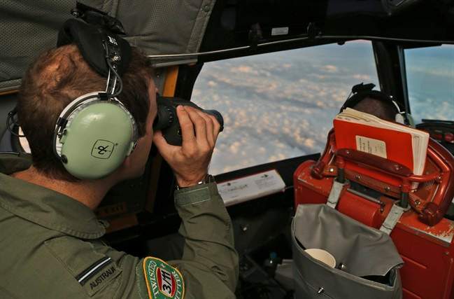 A Royal Australian Air Force P-3 Orion uses binoculars during the search for missing Malaysian Airlines flight MH370 in southern Indian Ocean, Australia. 