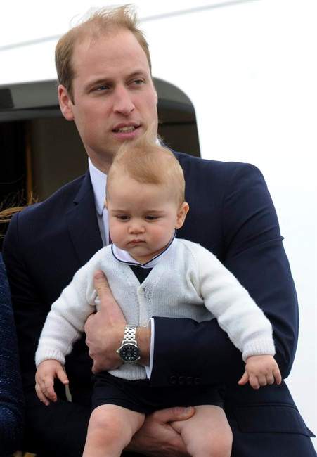 Britain ‘s Prince William carries his son Prince George as they depart for Sydney, Australia, from Wellington, New Zealand, Wednesday, April 16, 2014.