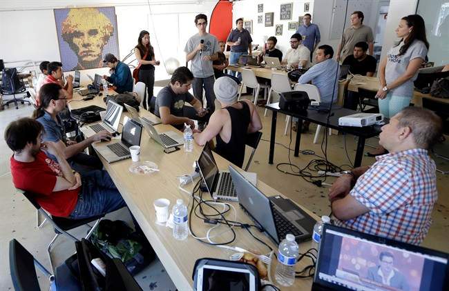 Raul Moas, center rear, executive director of the nonprofit organization Roots of Hope, addresses a group during a "Hackathon for Cuba" event run by Roots of Hope in Miami. 
