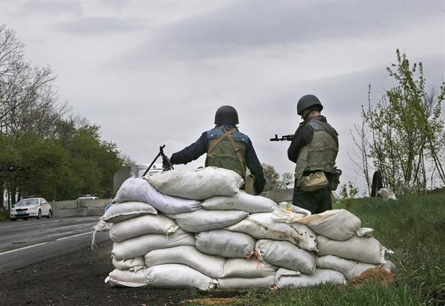 Ukrainian government troops guard a checkpoint near the village of Dolina, 30 kilometers (18 miles) from Slovyansk, eastern Ukraine, Tuesday, April 29, 2014. 