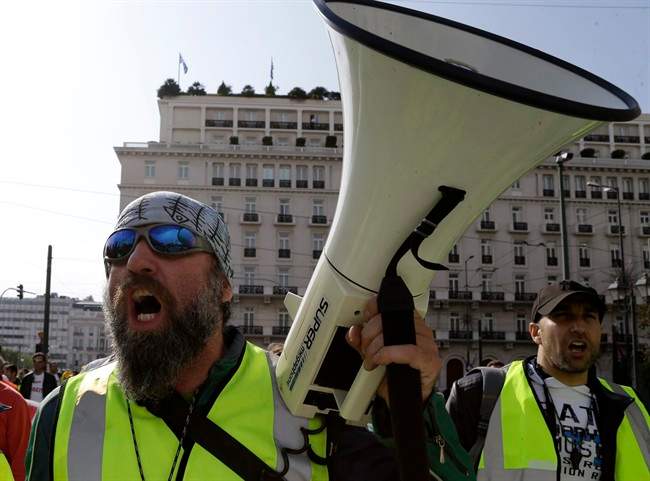 Protesters shout slogans during a rally by hundreds of striking port workers outside the Greek Parliament in Athens, on Tuesday, April 8, 2014. Greek dock workers across the country walked off the job Tuesday in a 48-hour strike to protest plans to sell stakes of the Piraeus Port Authority, the country's largest port and Thessaloniki port. Greece's Finance Ministry says the lower cost and stronger investor appetite for the country's latest short-term debt issue bodes well for a planned return to bond markets in coming months.