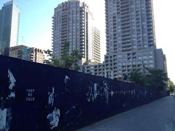 Boards surround an empty plot of land at 11 Wellesley in Toronto on July 13, 2012.
