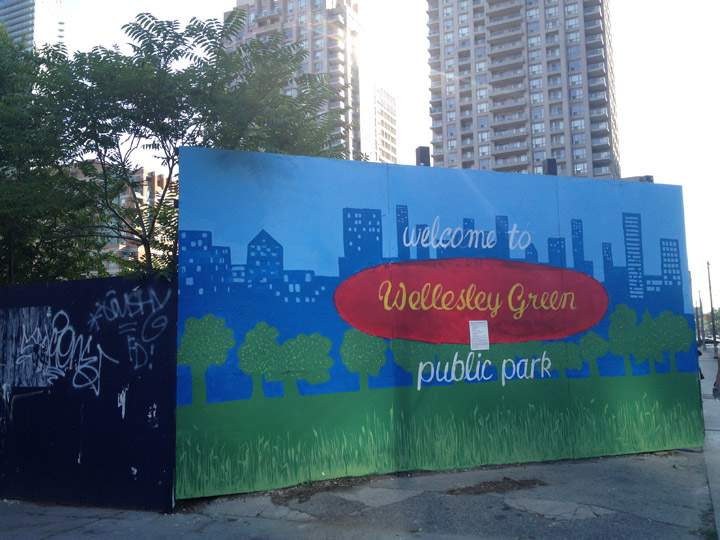 A plea for a community park is painted on boards surrounding an empty plot of land at 11 Wellesley in Toronto on July 13, 2012.