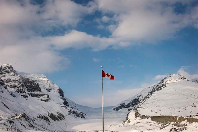 The Canadian flag flies over the Athabasca Glacier part of the Columbia Icefields in Jasper National Park.