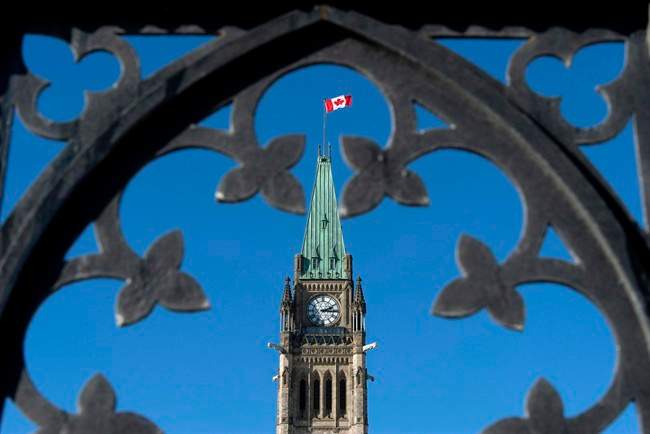 Centre Block's Peace Tower is shown through the gates of Parliament Hill, Feb. 11, 2014.
