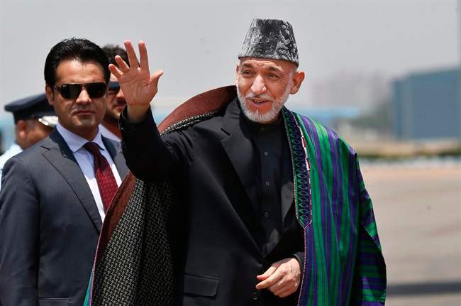Afghan President Hamid Karzai waves upon arrival for the swearing in ceremony of India's prime minister elect Narendra Modi in New Delhi, India, Monday, May 26, 2014.