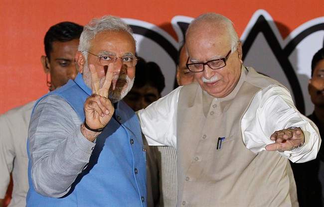 Opposition Bharatiya Janata Party (BJP) leader and India's next prime minister Narendra Modi, left, flashes the victory symbol standing next to senior party leader L.K. Advani at the party headquarters in New Delhi, India, Saturday, May 17, 2014.