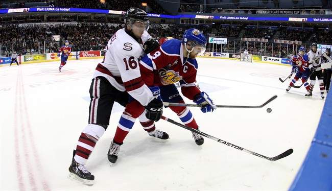 Guelph Storm's Kerby Rychel battles for the puck with Edmonton Oil Kings' Griffin Reinhart during second period Memorial Cup action in London, Ontario, Saturday, May 17, 2014.
