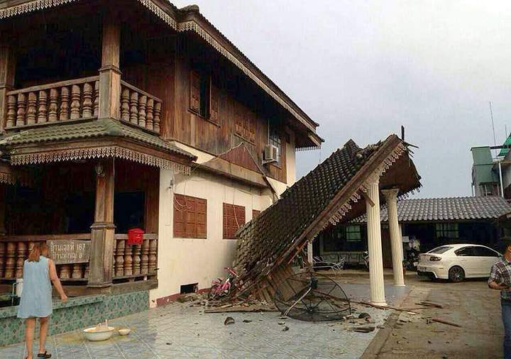 A woman looks at a partly damaged house following an earthquake in Chiang Rai province, northern Thailand Monday, May 5, 2014. A strong earthquake shook northern Thailand and Myanmar on Monday evening, and some light damage was reported. (AP Photo)