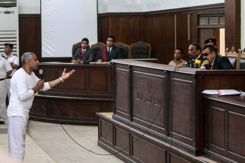 Qatar-owned broadcaster's English channel Al-Jazeera Cairo bureau chief Mohamed Fahmy (L) speaks to Egyptian judge Mohamed Nagy Shehata (R) after being allowed to leave the defendant cage during the trial of 20 individuals, including five Al-Jazeera journalists, for allegedly defaming the country and ties to the blacklisted Muslim Brotherhood on May 3, 2014 in the police institute near Cairo's Turah prison. AFP PHOTO / MOHAMED EL-SHAHED .