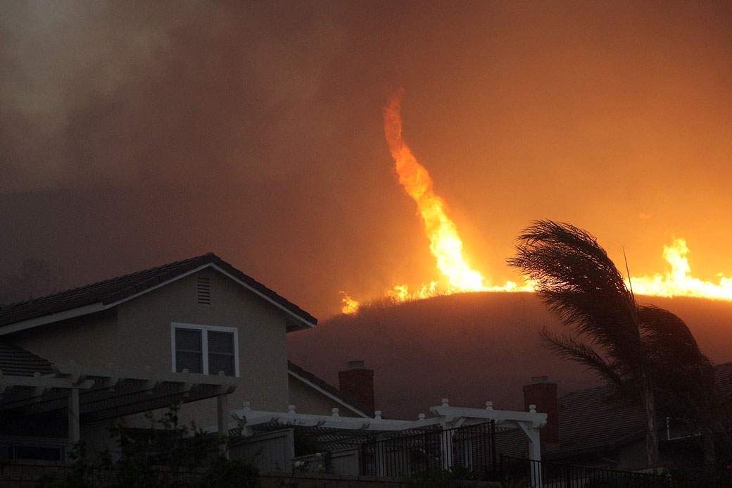 A fire tornado comes close to homes during the Corona Fire on November 2008.