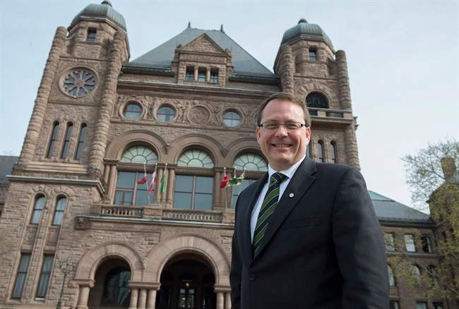 Green Party leader Mike Schreiner poses for a photo in front of the Ontario Legislature in Toronto on Wednesday May 7, 2014. 