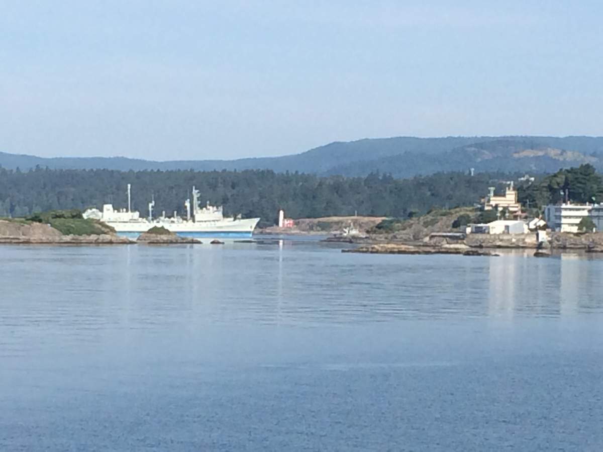 HMCS Protecteur being towed into port.