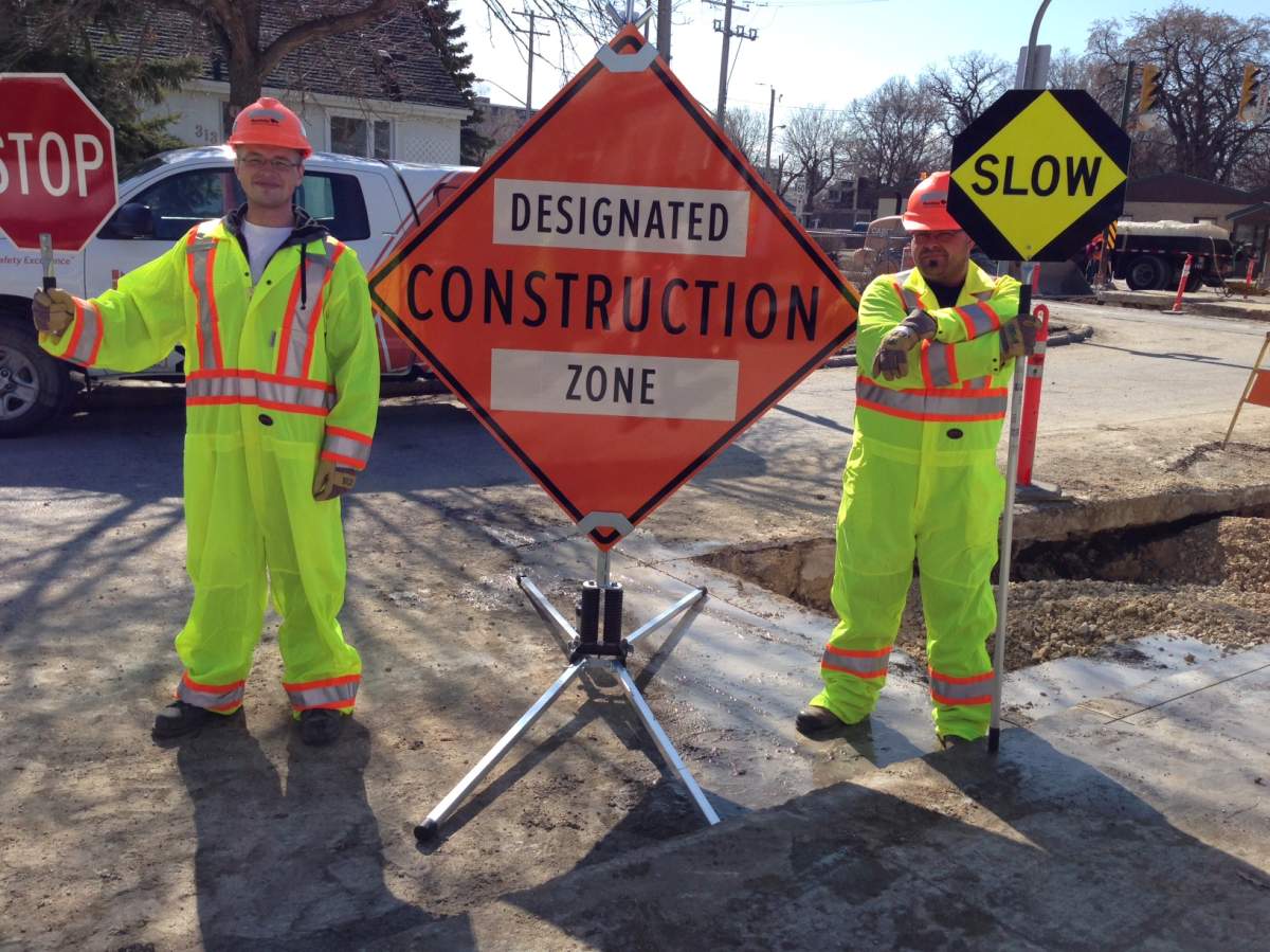 Construction workers display new road signs .