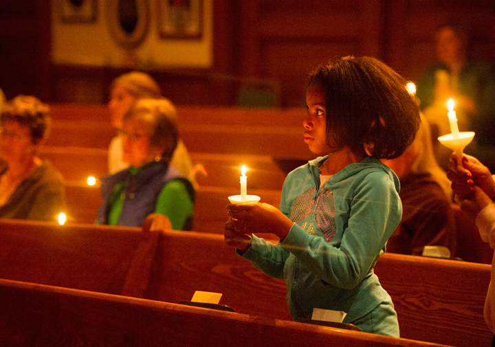 Karilyn Coates, 10, joins others in a candlelight vigil for the more than 300 girls abducted by Boko Haram in Nigeria, at All Souls Unitarian Church in Colorado Springs, Colo., Thursday, May 8, 2014.